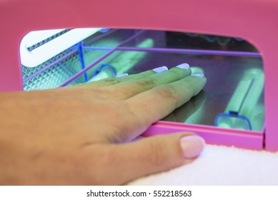 Female Hand In The Manicure UV Gel Curing Lamp.