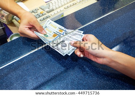 Female hand with money in cash department window. Currency exchange concept. American dollar. us dollar.  cash on counter bank. Hand giving cash and hand receiving cash. payday  paying cashier access
