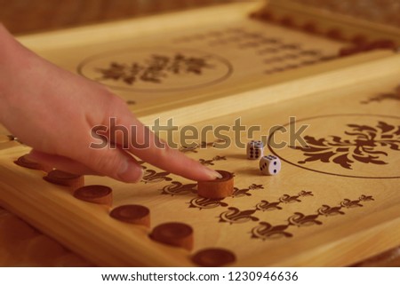 Female hand moves a backgammon chip
