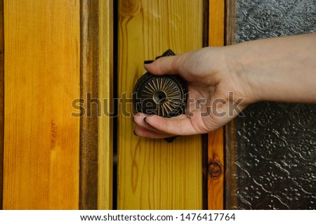 Female hand on a metal door handle