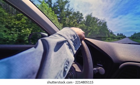 Female Hand On The Steering Wheel Of A Car. Focus On The Hand Wide View. Travelling By SUV Vehicle. Family Car Trip. Bumpy Country Road.