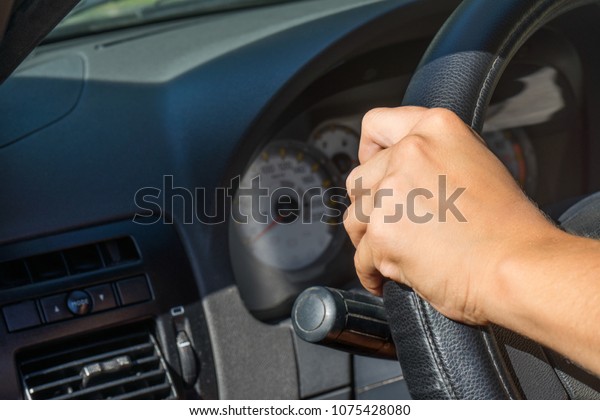 Female hand on steering\
wheel