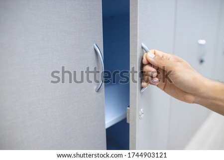 Female hand open the cupboard doors, close up