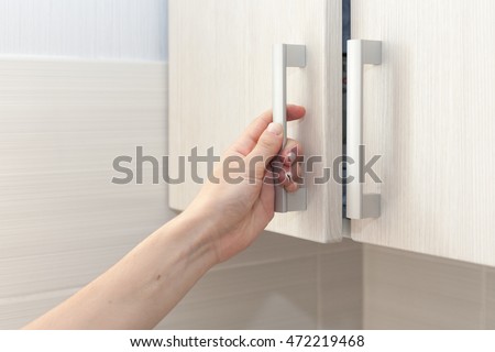 Female hand open the cupboard doors, close up