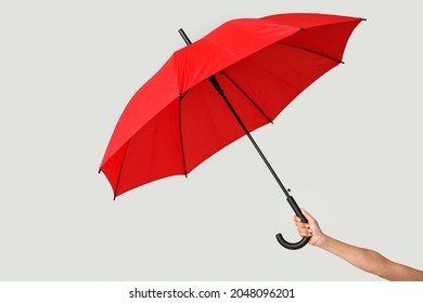 Female hand with open umbrella on light background - Shutterstock ID 2048096201