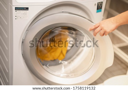 Female hand opening the washing machine prepare wash the clothes, for the hygience and cleaning.