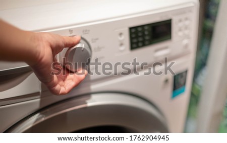 Female hand opening the washing machine and the space for detergent liquid preparing wash the clothes, for the hygience and cleaning.