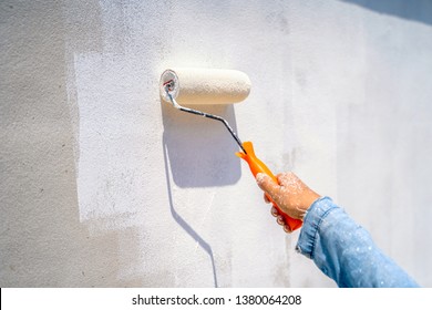 Female Hand Painting Wall With Paint Roller