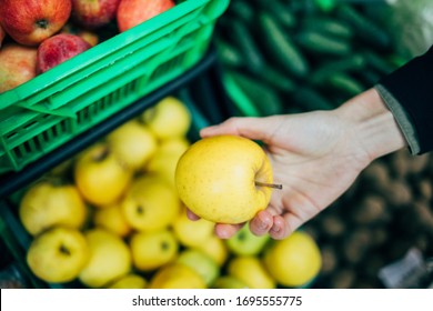 Female Hand Picking Apple From Shelf In Grocery Store, Close-up.