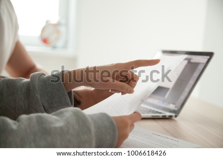 Female hand pointing on document paying attention to important term considering contract, couple holding papers analyzing deal conditions protecting from fraud, reading instructions report, close up