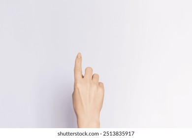 Female hand pointing upwards with index finger, close-up on  an empty white background. - Powered by Shutterstock