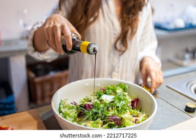 Female Hand Pouring Balsamic Vinegar On The Fresh Vegetables Salad