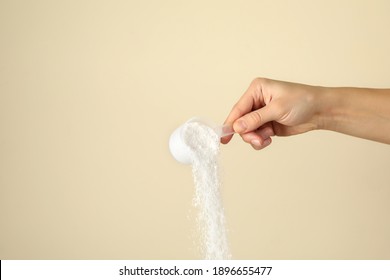 Female hand pouring washing powder on beige background - Shutterstock ID 1896655477