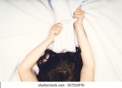 Female hand pulling white sheets in ecstasy, orgasm.
