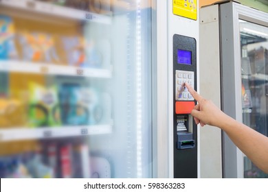 Female Hand Push Button to make Transaction Code or Number on Modern Automatic Vending Machine with Digital Display.  This Machine Can be operated with Both coin and Banknote. - Shutterstock ID 598363283