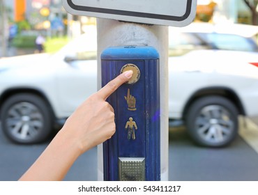 female hand pushing button for traffic light