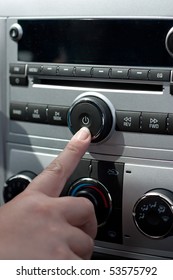 A Female Hand Pushing The Power Button To Turn On The Car Stereo System.