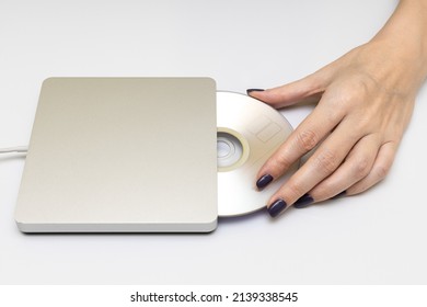 Female Hand Puts A Laser Disc Into The Drive. High Quality Photo