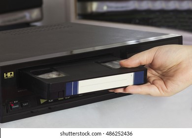 Female Hand Puts Old Video Tape into the Old Video Player.