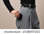 female hand putting black premium credit bank card in pants pocket. Money finance