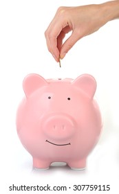 Female Hand Putting Coin Into Piggy Bank Isolated On White