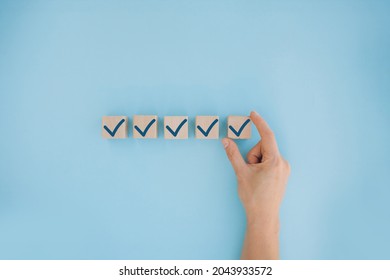 Female Hand Putting Down The White Tick Marking Wooden Cube For Checklist Or To Do List Concept