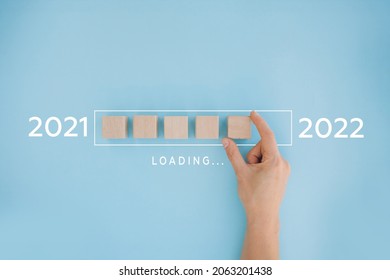 Female hand putting wooden cube for countdown to 2022. Loading year from 2021 to 2022. New year start concept - Shutterstock ID 2063201438