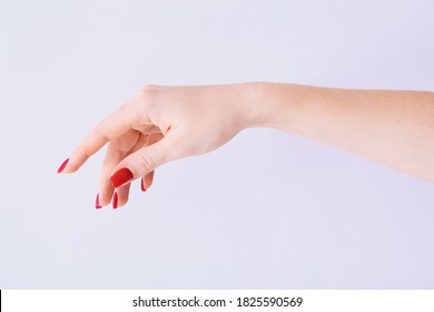 Female hand with red manicure on light grey background