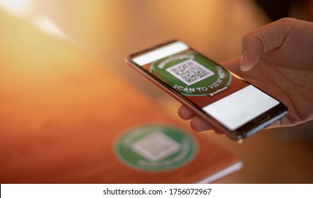 Female hand scanning the QR code with mobile phone for order foods and pay at the restaurant for the new technology e-wallet and e-payment.