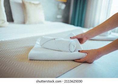 Female Hand set up white bed sheet in bedroom. Close-up of a maid's hands making bed in a hotel room. Making Bed. Maid working making the bed at a hotel. 