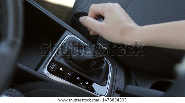 Female hand shifts gears. New\
car.