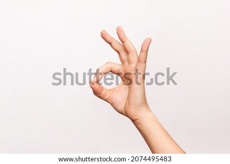 Female hand showing the ok gesture isolated on a white background. Okey hand sign