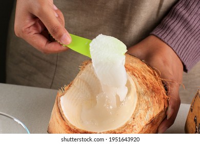 Female Hand Shredded  Young Coconut Flesh to the Bowl, Preparation Making Es Kelapa Muda (Young Coconut Ice) for Ramadan Breakfasting