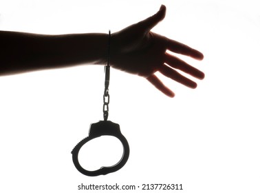 Female Hand Silhouette With Handcuffs, On The White Background.