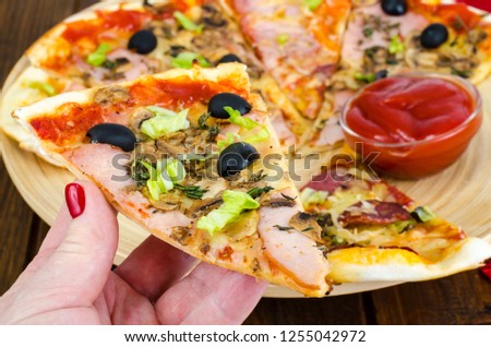 Female hand with slice of pizza. Studio Photo