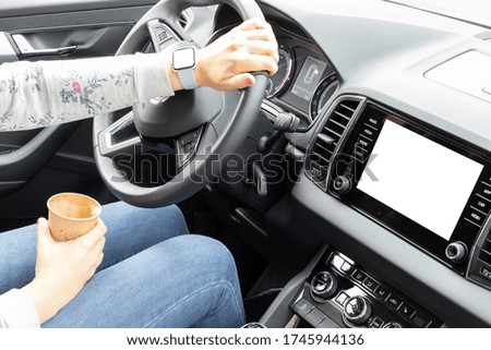 Female hand with smart watch on the steering wheel of a car while driving.