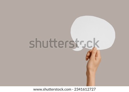 Female hand with speech bubble on grey background