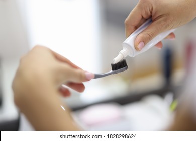 Female Hand Squeezing Toothpaste From Tube Onto Toothbrush Close-up. Daily Oral Care After Meals Concept.