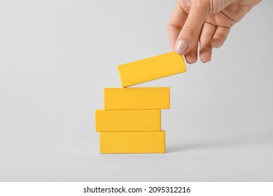 Female Hand Stacking Blocks On Light Background