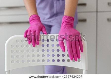 female hand in sterile pink gloves