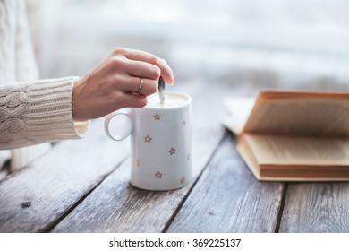 Female Hand Stir Coffee On Wooden Table