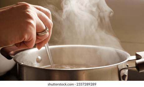 Sopa hirviendo a mano hembra en olla. Nutrición saludable, cocina en casa, vapor caliente