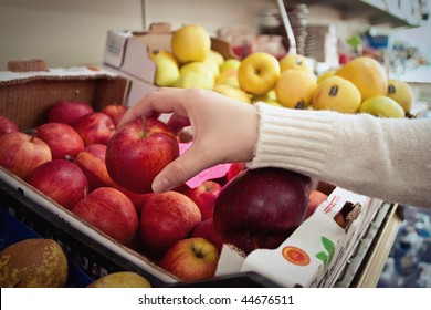 Female hand taking fruit from a shelf - Powered by Shutterstock