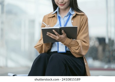 Female hand taking notes on a notebook handwritten note writing business schedule in the morning. - Powered by Shutterstock