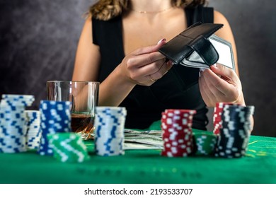 Female Hand Taking Poker Chips From Pile At Round Poker Table. Risky Bets In Poker