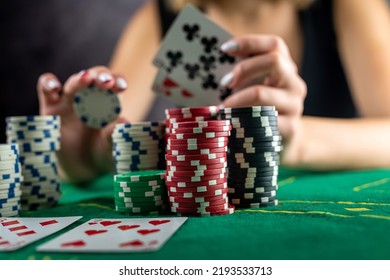 Female Hand Taking Poker Chips From Pile At Round Poker Table. Risky Bets In Poker