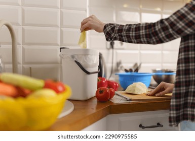 Female hand throwing organic food waste in a domestic compost bin with bokashi - Powered by Shutterstock