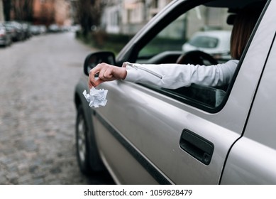 Female Hand Throwing Trash Out Of Car Window.