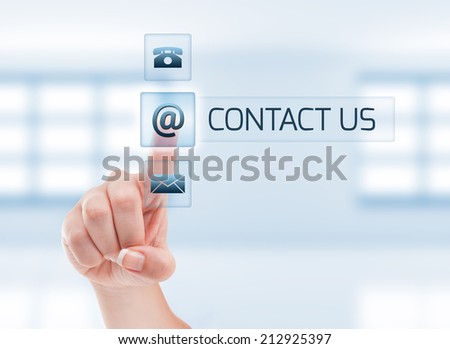 Female hand touching contact us button. Futuristic contact us concept on light blue