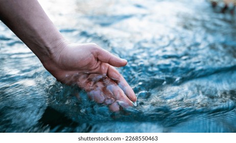 A female hand touching the river water - Powered by Shutterstock